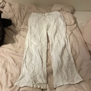 Vita vida linnebyxor med snörning - Säljer ett par fräscha vita linnebyxor med breda ben och skön passform. Byxorna har snörning i midjan för extra komfort och är perfekta för varma dagar. Lätta och luftiga, passar dig som gillar en avslappnad och stilren look.