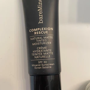 bareMinerals Complexion Rescue Tinted Moisturizer - bareMinerals Complexion Rescue Natural Matte Tinted Moisturizer med SPF 30. Ger en naturlig matt finish och återfuktar huden. Tuben rymmer 35 ml och är svart med guldtext. Innehåller mineralbaserat solskydd och passar dig som vill ha lätt täckning.