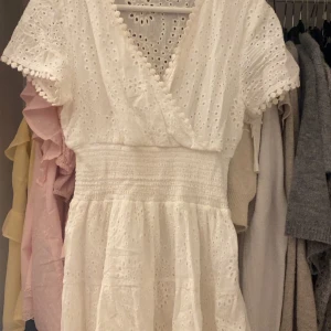 Vit omlottklänning med spetsdetaljer -  vit omlottklänning