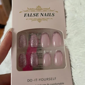 Rosa lösnaglar med glitter - Snygga lösnaglar i ljusrosa med silvrigt glitter. Några naglar är helt täckta av glitter medan andra har glittertippar för en trendig look. Perfekt för att fixa naglarna snabbt hemma. Innehåller nagellim.