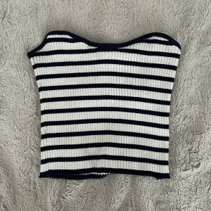 Randig ribbad tubtopp - Säljer en ribbad tubtopp med marinblå och vita ränder. Toppen är bandeau-modell och har en tight passform som sitter snyggt på kroppen. Perfekt för sommardagar eller när du vill ha en chill och stilren look! 💘💘