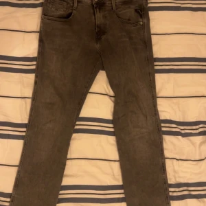 Replay Anbass grå jeans - Snygga grå jeans från Replay, modell Anbass. Klassisk femficksdesign med raka ben och normal passform. Jeansen har Replay-logga på fickan och är tillverkade i ett mjukt denimtyg som sitter skönt hela dagen. Köpta i Åhléns, Sthlm.