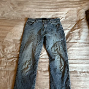 Blå jeans från Gant Jeans - Klassiska blå jeans från Gant Jeans med raka ben och normal passform. Jeansen har fem fickor, knappgylf och tydliga sömmar. Perfekta för en avslappnad stil och funkar året runt.