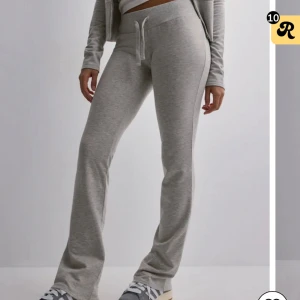 Low waist sweatpants från Nelly - Säljer ett par ljusgrå mjukisbyxor från Nelly med låg midja. Byxorna har använts men är i bra skick. Säljs då de sitter för tajt. Nypris 299!