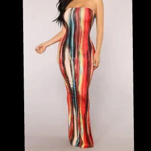 Färgglad axelbandslös långklänning - Maxi dress från Fashion nova med färgstarka vertikala ränder i rött, blått, svart, beige och gult. Klänningen är tight och figurnära med en snygg, slät passform.