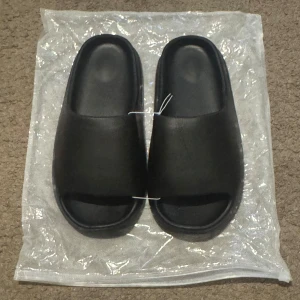 Tofflor Slides  - Svarta tofflor slides.                                                   Size: 39-40.                                                          Perfekta för en chill och avslappnad stil under varmare dagar.
