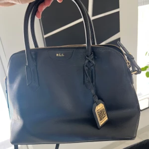 Damväska - Hej, hjälper mamma att rensa garderoben. Säljer då denna snygga väska i svart skinn för ett riktigt bra pris. Väskan är i grymt skick och säljs billigt pågrund av ingen användning. Först till kvarn!