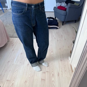 Mörkblå raka jeans - Säljer ett par klassiska mörkblå jeans med rak passform och normal midja. Jeansen har fem fickor, knapp och dragkedja. För långa på mig som är 165 cm. 