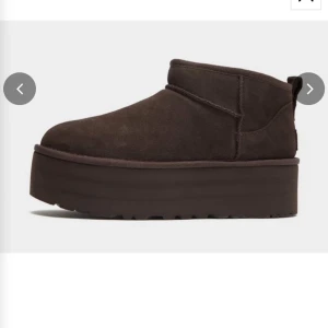 Bruna UGG mini platform  - Mörkbruna boots från UGG med hög platåsula och rund tå. Skorna är tillverkade i mocka och har en mjuk, fodrad insida. Perfekta för kyligare dagar och ger en trendig look med sin chunky sula. Använda 2-3 gånger och därför i superfint skick! Skriv för fler bilder