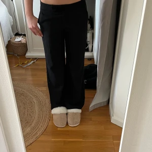 Svarta kostymbyxor - Midjemått: 38 Innerbenslämgd: 73 Snygga svarta kostymbyxor med en klassisk design. Byxorna har en rak passform och är perfekta för en stilren look. De är tillverkade i ett bekvämt material och har en diskret dragkedja framtill.