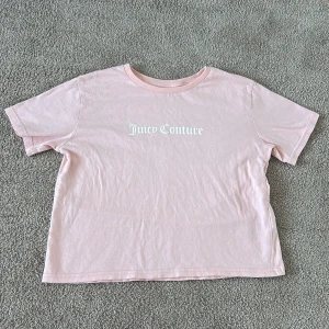 Rosa t-shirt från Juicy Couture - Säljer en söt rosa t-shirt från Juicy Couture med deras ikoniska logga tryckt på framsidan. T-shirten är kortärmad och gjord i mjukt bomullsmaterial. Den är knappt använd💕💕