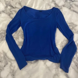 Blå långärmad topp - Snygg blå långärmad topp med rund halsringning. Perfekt för en stilren look. Passar bra till både jeans och kjol.
