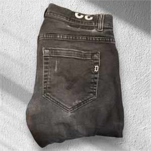 DONDUP George Jeans Grå - Säljer ett par grå jeans från Dondup i modellen George. Jeansen är i mycket fint skick med minimal användning. Jeansen är i storlek 32! En stilren och bekväm modell med hög kvalitet som passar både till vardag och mer uppklädda tillfällen! 🙌🤝