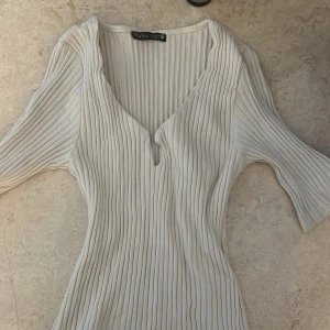Beige ribbad topp från PAYNA - Säljer en stilren beige ribbad topp från PAYNA med v-ringning och trekvartsärmar. Har inte haft den på mig. 