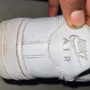 Vita Nike Air Force sneakers - Säljer ett par klassiska vita Nike Air Force sneakers. Skorna har snörning och är tillverkade i skinn med perforerade detaljer på tån för extra ventilation. Perfekta för en stilren look.