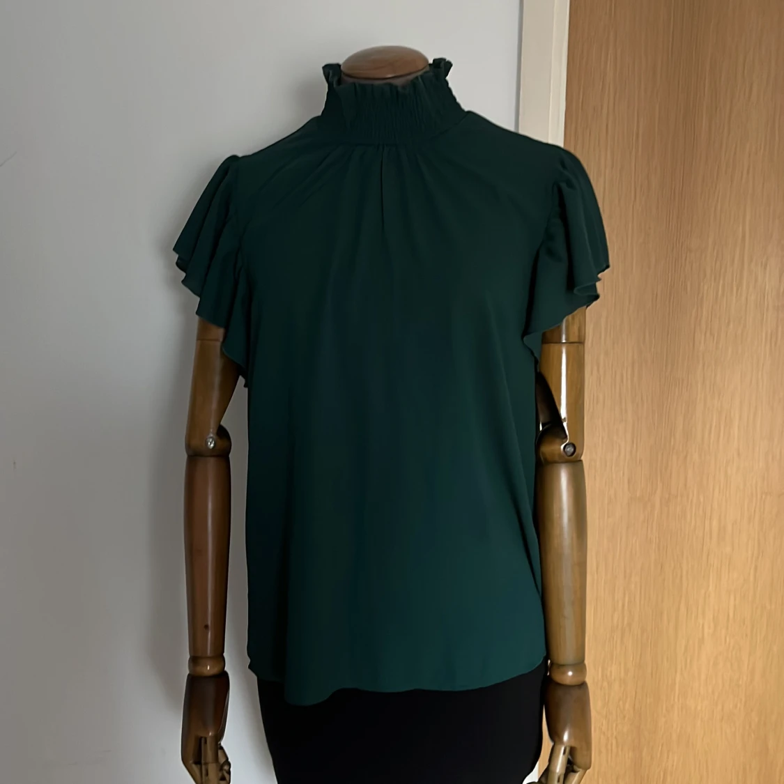 Mörkgrön blus med volangdetaljer