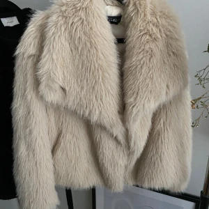 Beige pälsjacka från Laseti - Säljer en supermjuk och fluffig beige pälsjacka från Laseti. Jackan har en elegant design med långa ärmar och en stor krage som ger en lyxig känsla. Perfekt för att hålla sig varm och stilren under kyliga dagar. Jackan kostade från början 1700 och är ifrån Italien.