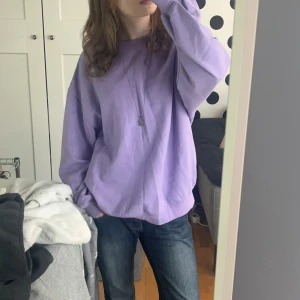 Lila sweatshirt från H&M - Säljer en lila sweatshirt från H&M i storlek S. Tröjan har en avslappnad passform med långa ärmar och ribbade muddar vid ärmslut och nederkant. Perfekt för en bekväm och stilren look. 💜