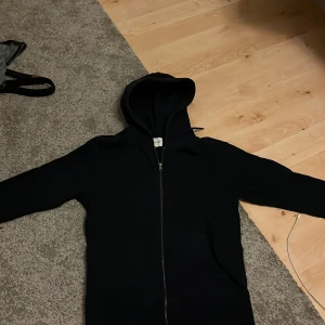 Mörkblå hoodie med dragkedja - Säljer en stilren mörkblå hoodie med dragkedja. Perfekt för en avslappnad look. Den har långa ärmar och en praktisk huva.