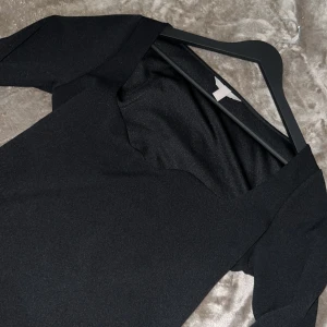 Svart långärmad topp - Snygg svart långärmad topp med en elegant design. Perfekt för att klä upp eller ner beroende på tillfälle. Den har en stilren look och är gjord i ett mjukt material.