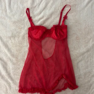 Röd spetstopp från La Senza - Toppen har en transparent design med volangdetaljer vid fållen och små rosetter vid axelbanden. Perfekt för en speciell kväll! ❤️