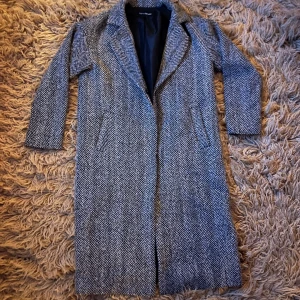 Grå kappa med fiskbensmönster - Svartvit kappa med fiskbensmönster, i fint skick.