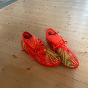 Röda och gröna fotbollsskor från Adidas - Säljer ett par iögonfallande röda och gröna fotbollsskor från Adidas. Storlek 42. Den är bara använda ett fåtal gånger