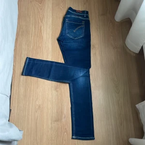 Mörkblå dondup jeans - Snygga mörkblå dondupjeans av modellen George slim fit. Jeansen är endast använda ett fåtal gånger och därför i väldigt bra skick.