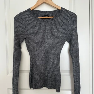 Grå ribbad tröja från Even&Odd - Säljer en grå ribbad tröja från Even&Odd. Tröjan har en fin passform och långa ärmar, perfekt för kyligare dagar. Aldrig använd. Passar olika storlekar då den är stretchig. 