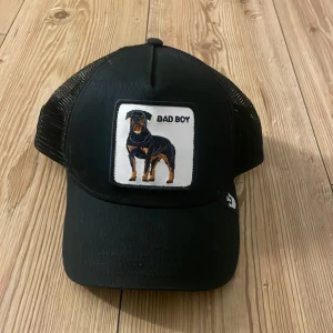 Keps från ”the farm” - Snygg svart keps med ett broderat motiv av en hund och texten 'Bad Boy' på framsidan. Knappt använd, nypris= 400-500. Inga defekter❤️❤️