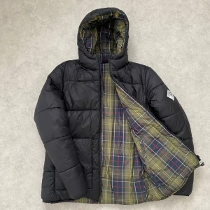 Svart dunjacka från Barbour - Säljer min Barbour pufferjacka (vinterjacka) som köptes i december, nypris 2500 kr. Den är väldigt sparsamt använd och därmed i bra skick. Storleken är S, men eftersom den är oversized passar den även dig som vanligtvis använder storlek M, precis som jag