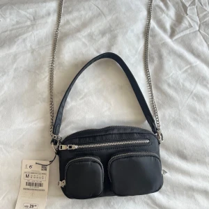 Svart axelväska med kedja - Svart liten väska från Zara.  Aldrig använd! 