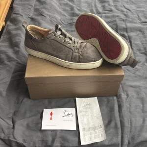 Grå sneakers från Christian Louboutin - Snygga grå Christian Louboutin skor även riktigt stilrena också strl 42. Kvitto och andra äkte hets bevis följer med plus kartongen 