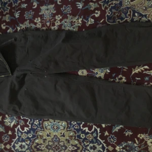 Carharrt double knee - Säljer ett par bruna byxor från Carhartt med en klassisk design. Byxorna har flera fickor och dubbel knee 