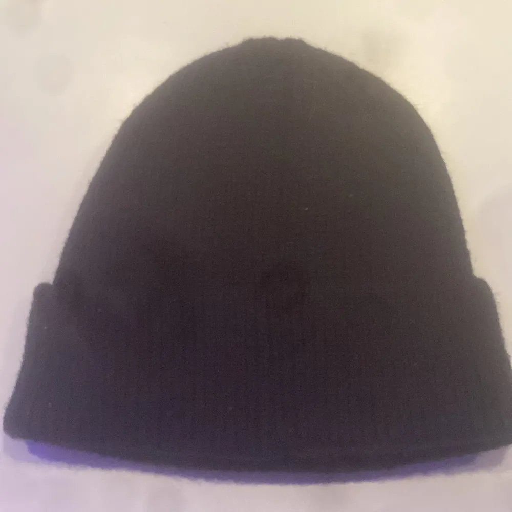 Snygg svart mössa från C.P. Company med unika glasögondetaljer framtill. Perfekt för att ge din outfit en cool touch. Tillverkad i ett mjukt och bekvämt material.. Asusteet.