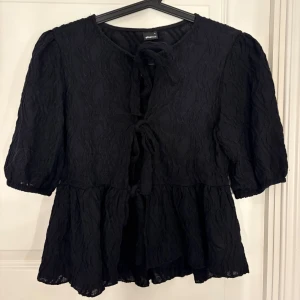 Svart blus  - Säljer denna super fina blusen med knytning! Den är köpt på Ginatricot och är knappt använd💕