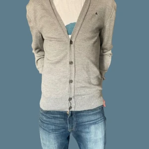 Grå kofta från J.Lindeberg 100% merino ull - Passar S. Snygg grå kofta från J.Lindeberg med knappar framtill. Perfekt för lager-på-lager och har en diskret logga på bröstet. Passar både till jeans och chinos för en stilren look. 100% merino ull 