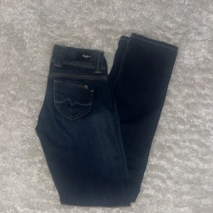 Mörkblå jeans med knappar - Snygga mörkblå jeans med klassisk design och knappar i midjan. Perfekta för en avslappnad stil. Kom privat för mått💗