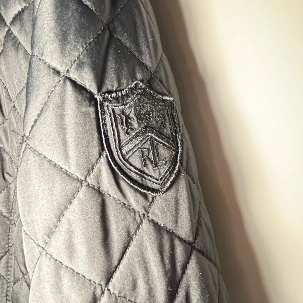 Snygg svart quiltad jacka från Ralph Lauren med knappar och dragkedjor. Jackan har en broderad logga på ärmen och praktiska fickor med dragkedja. Perfekt inför våren😀 Jackan är i storlek XL men passar L. Tveka inte på att ställa frågor!😀. Takit.