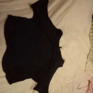 Svart tröja från Divided - Säljer en enkel och stilren svart tröja från Divided. Perfekt för en avslappnad look. Tröjan har en normal passform och är tillverkad i ett mjukt material. Har två snygga hål på ärmarna som gör den extra snygg och stilren!