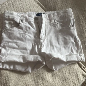 Vita shorts från GANT - Säljer ett par stilrena vita shorts från GANT. De är midrise med klassisk femficksdesign och uppvikta benslut. Perfekta för en somrig look!