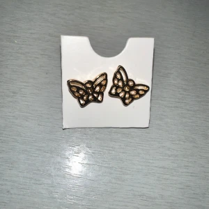 Guldiga fjärilsörhängen - Snygga guldiga örhängen i form av fjärilar. Perfekta för att lägga till en touch av elegans till din outfit. De har en fin detaljrik design som fångar ljuset vackert.