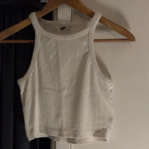 Vit ribbad linnetopp från NLY TREND - Säljer en stilren vit ribbad linnetopp från NLY TREND. Toppen har en enkel design med breda axelband och är perfekt för varma dagar. Passar bra till både jeans och kjol. Perfekt basplagg i garderoben!🥰