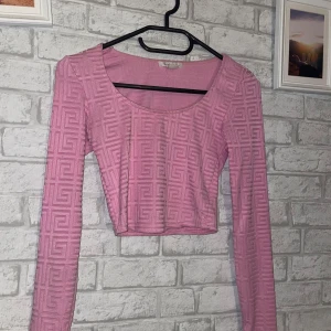 Rosa långärmad topp - Säljer en rosa långärmad topp med ett geometriskt mönster. Toppen är croppad och är i bra skick.