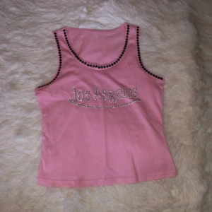 Rosa linnetopp med strassdetaljer - Säljer en söt rosa linnetopp med texten 'Los Angeles' i strass på framsidan. Aldrig använd då det inte riktigt är min stil 🥰