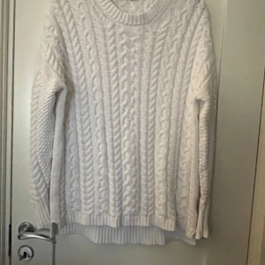 Vit stickad tröja från 157 - Säljer en mysig vit stickad tröja från 157. Tröjan har ett klassiskt flätmönster och långa ärmar. 
