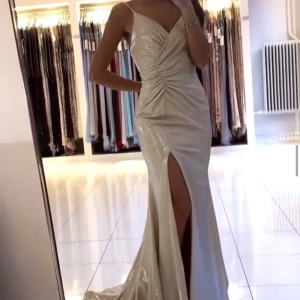 Balklänning Dressroom Linné - Balklänning i champagne från Dressroom Linné. Storlek: EU 34 (materialet är stretchigt). Använd en gång. Klänningen kommer med påse och galge. Ordinarie pris: 3390SEK