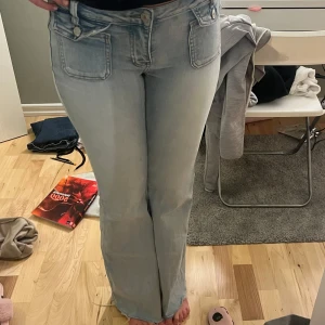 Ljusblå bootcut jeans från Queen Hearts - Snygga ljusblå bootcut jeans från Queen Hearts. De har en låg midja och klassisk femficksdesign med knappar och dragkedja. Strl 36-38. Passar mig som är 170 super bra. 