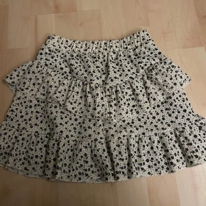 Blommig sommarkjol  - En fin och somrig kjol från Zara. Den har svarta blommor och lite volanger. Den passar xxs/xs och är i bra skick. Den har även short vilket är jätte skönt men det är ingenting som syns på utsidan varken bak eller fram till. 