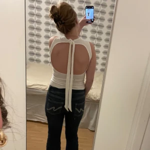 Vit ribbad linnetopp - Säljer en stilren vit ribbad linnetopp med öppen rygg och knytband i nacken. Köpt från Zara och har aldrig använt den mer än att prova den hemma. Prislappen är inte kvar men den är i helt nytt skick. Skriv till mig vid frågor eller för fler bilder☺️